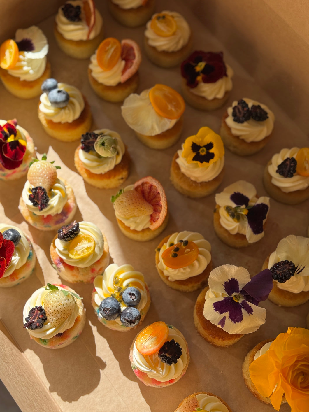 Mini cakes topped with fruit and florals